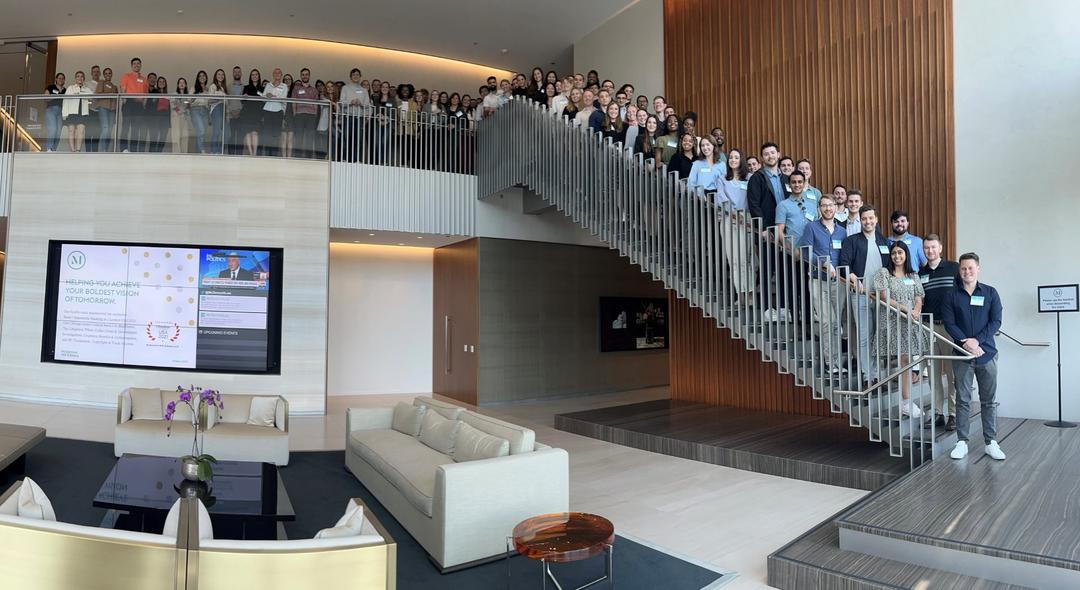 employees posing for a group shot on the stairs